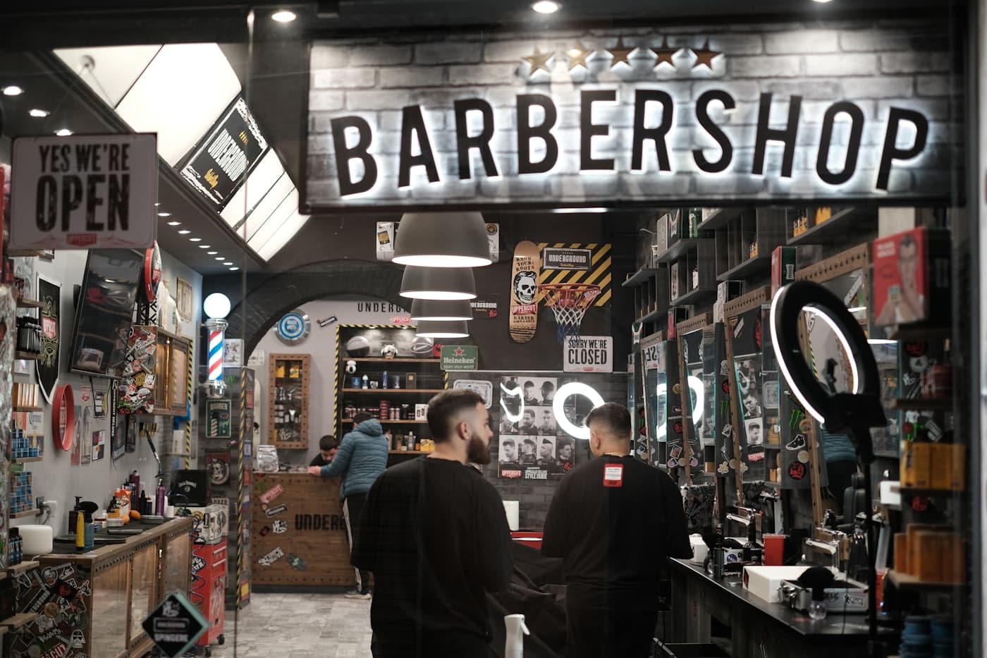 Interior de uma barbearia com letreiro e cadeiras
